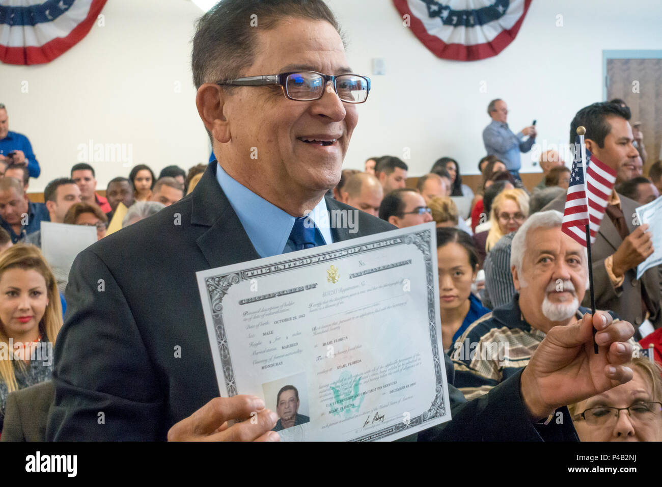 Just sworn in as American Citizens, immigrants wave flags and hold