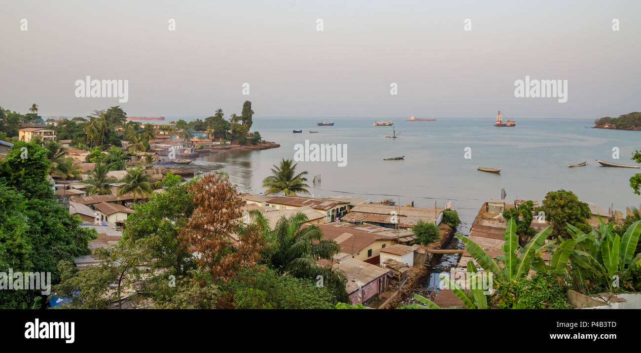 View over slums of Freetown at the sea where the poor inhabitants of this African capital city live with ships and boats in the bay, Sierra Leone, Afr Stock Photo