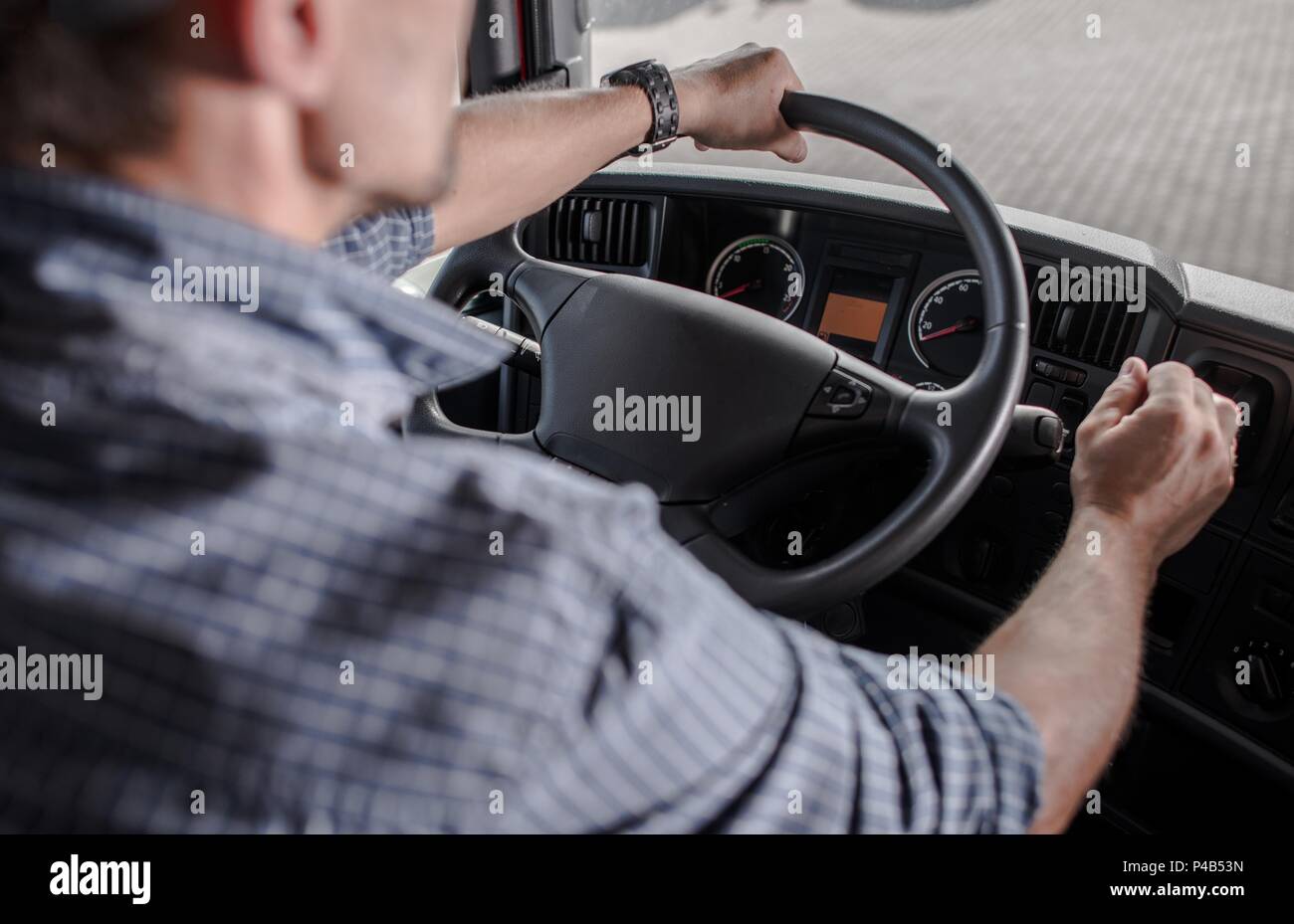 Transportation Industry Commercial Vehicle Driver. Caucasian Trucker Behind the Wheel. Stock Photo