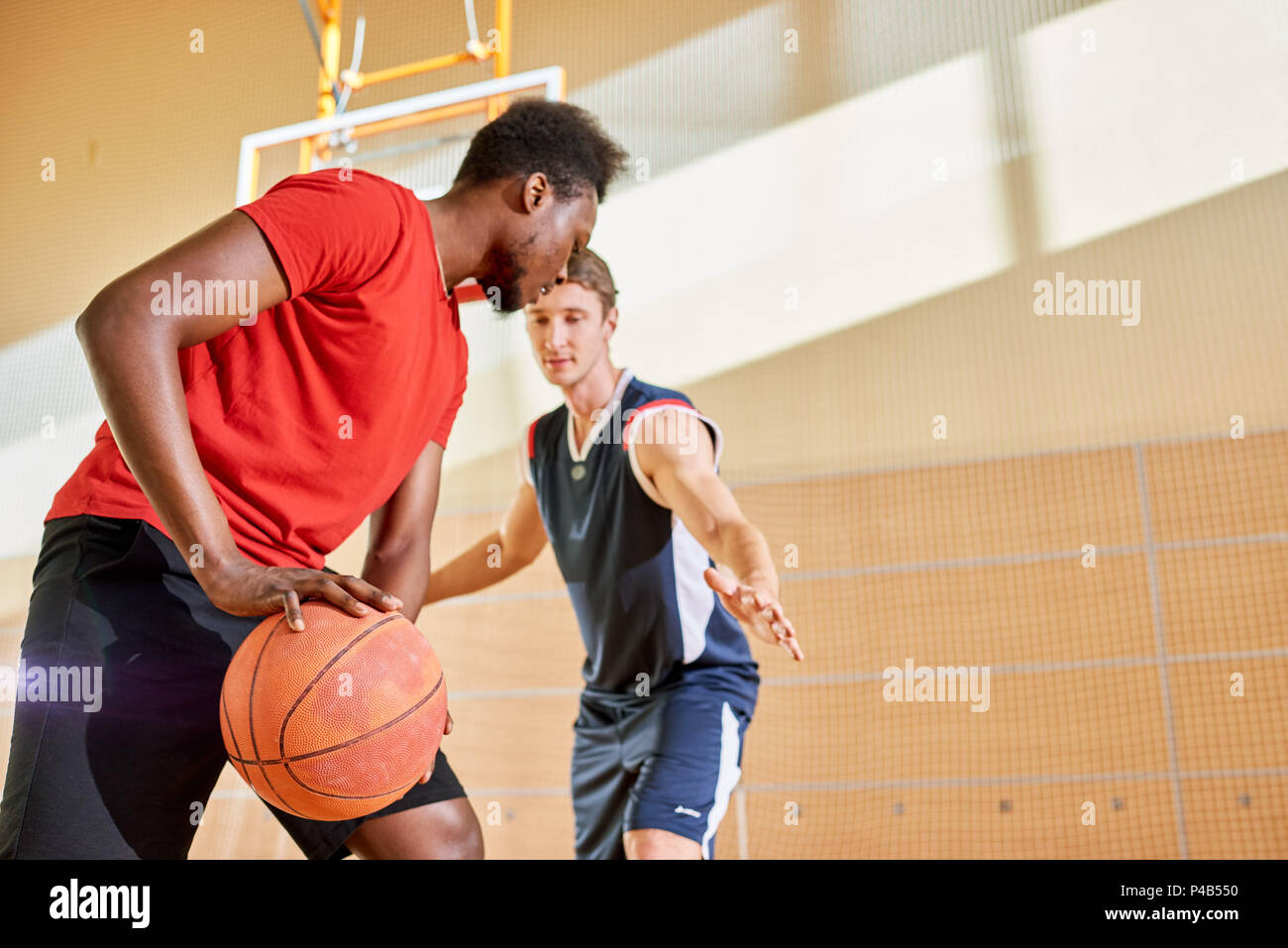 Men playing basketball together Stock Photo