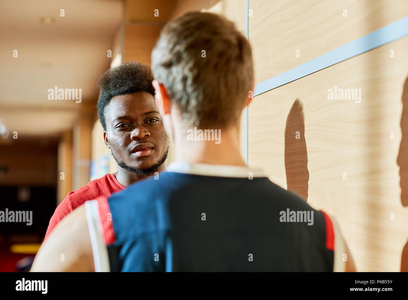 Basketball players talking in gym Stock Photo