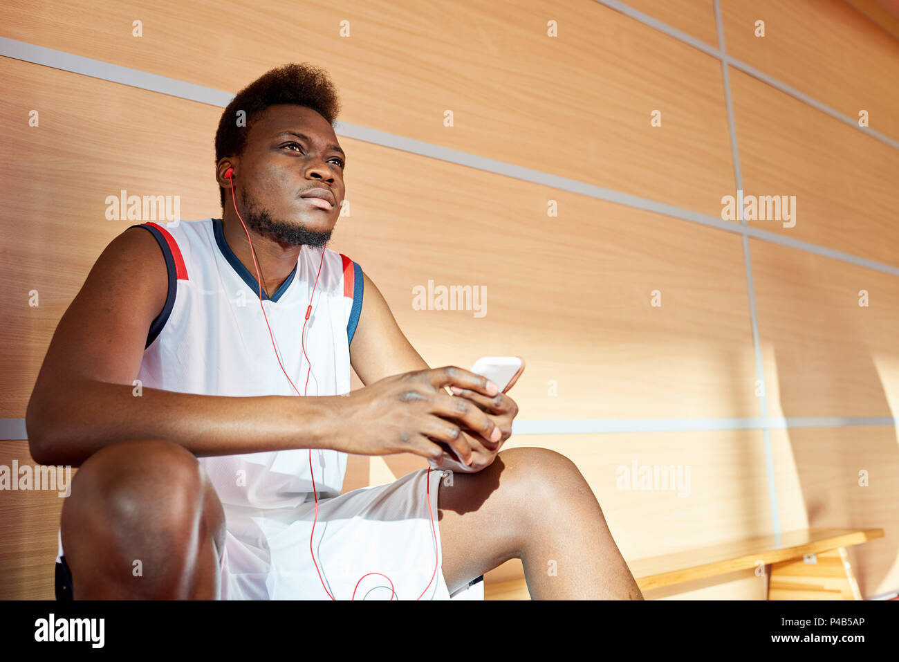 African-American athlete listening to music in gym Stock Photo