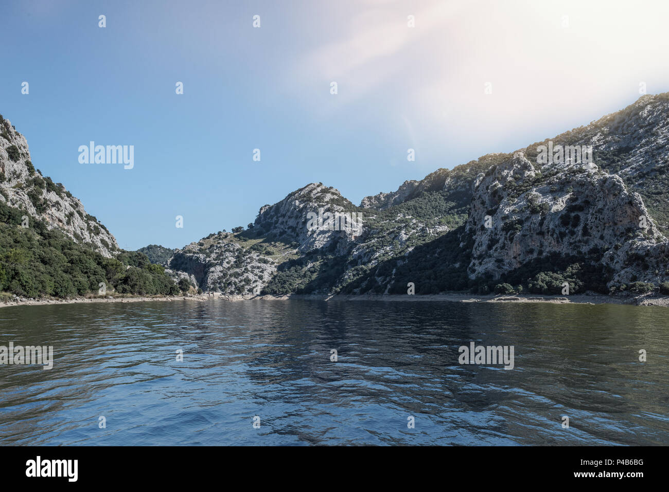 lake surrounded by mountains under blue sky Stock Photo