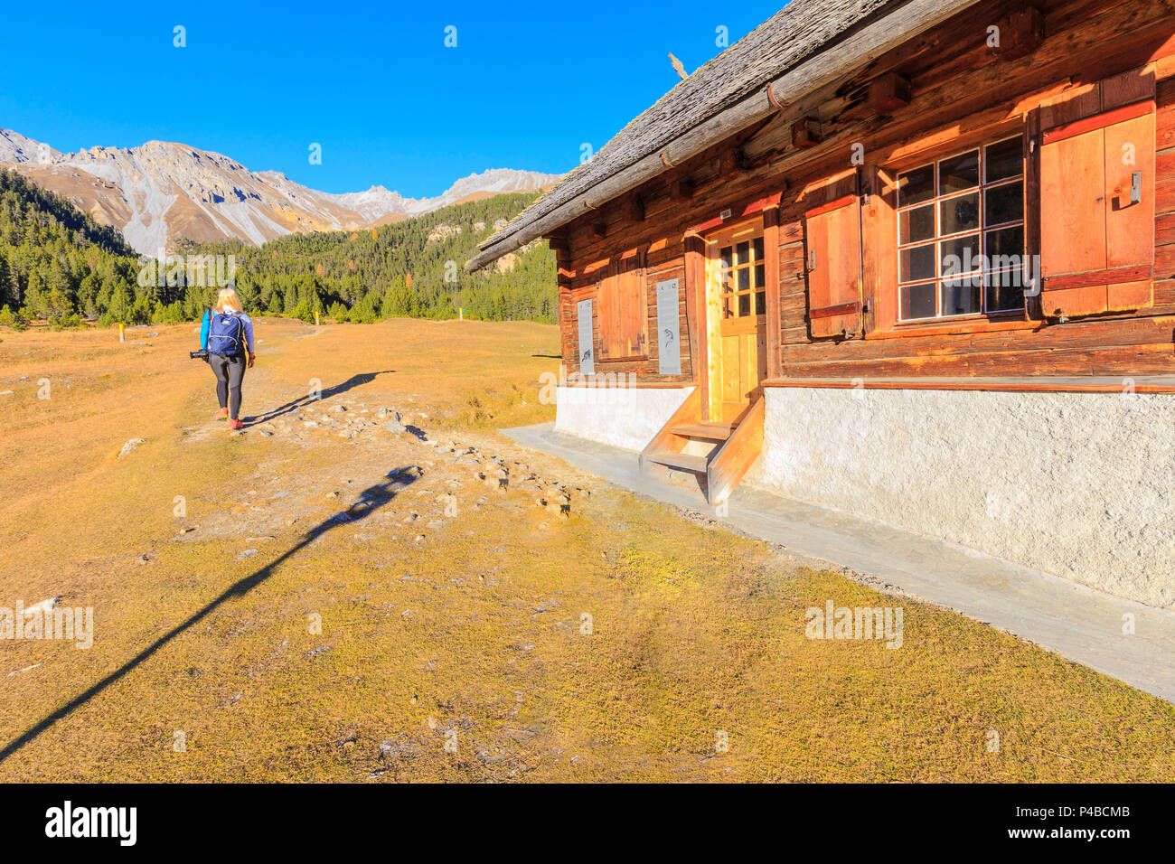 Girl walks near the House of the park at Alp Stabelchod, Pass dal Fuorn, Parc Naziunal Svizer, Engadine, Graubünden, Switzerland. Stock Photo