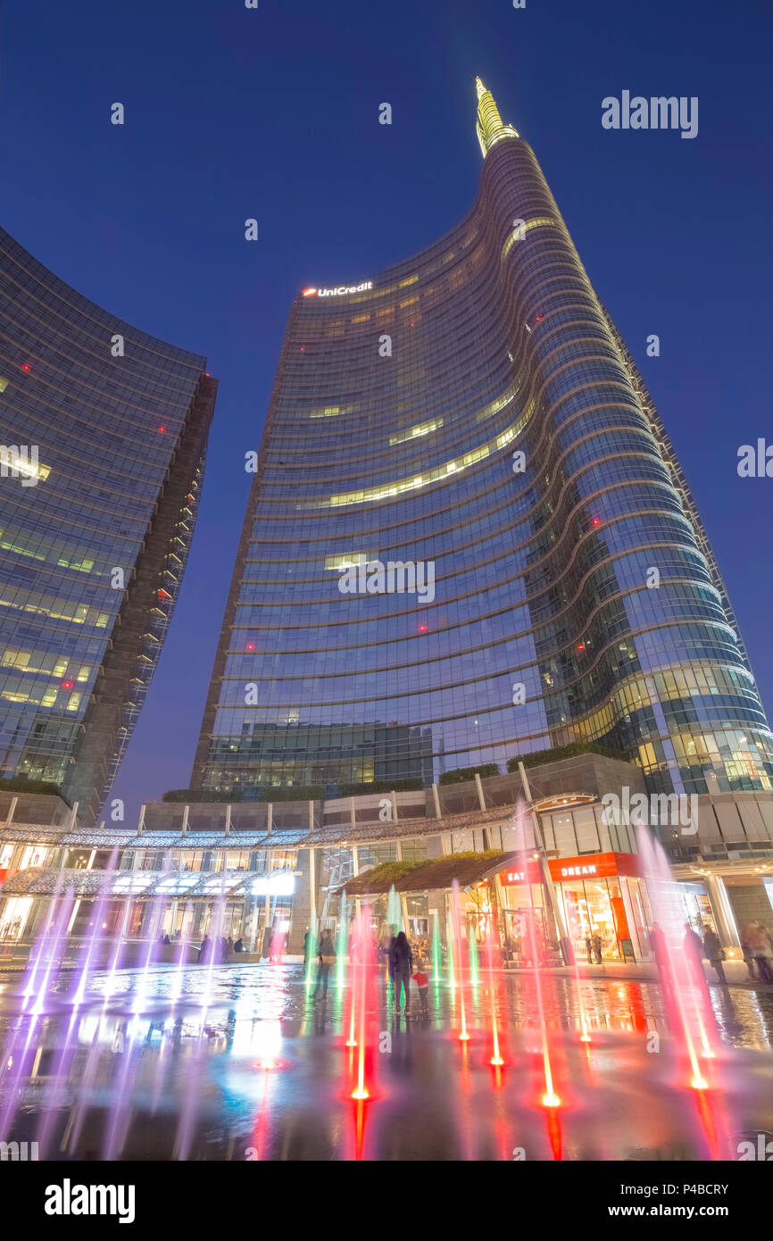 View of the Unicredit Tower from the fountains in Gae Aulenti square during the evening. Milan, Lombardy, Italy. Stock Photo