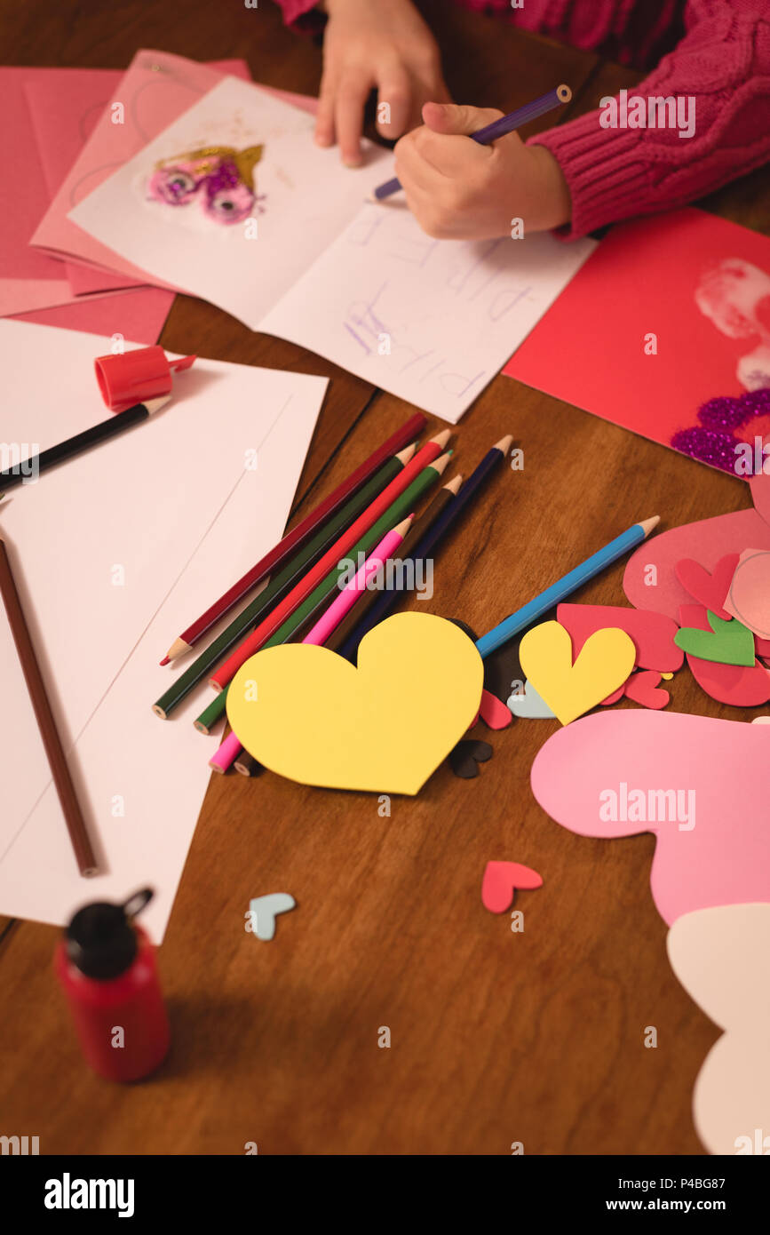 Girl drawing on valentine card Stock Photo