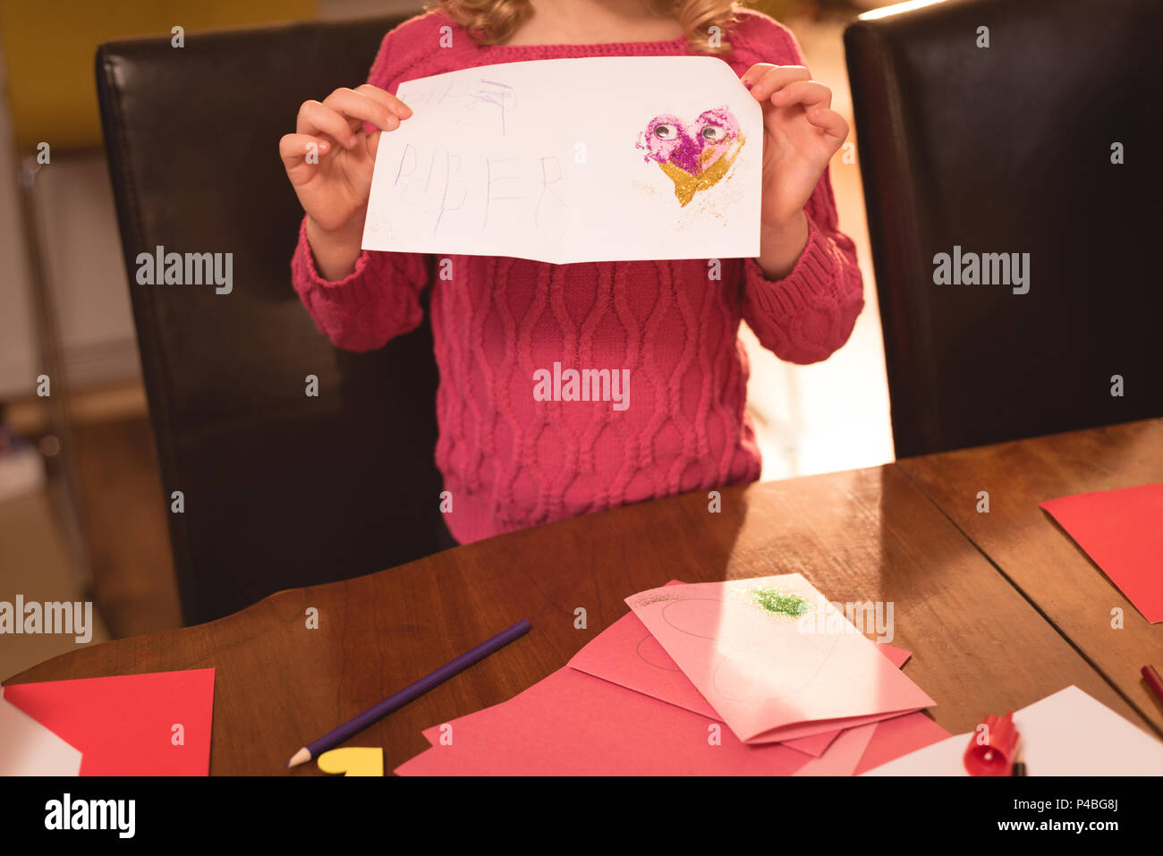 Girl showing valentine card at home Stock Photo