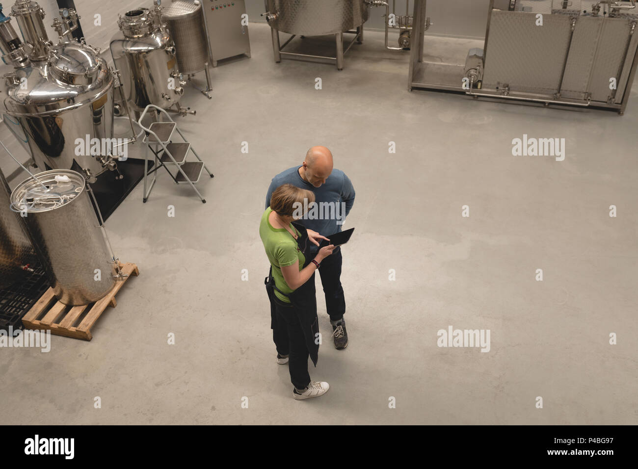 Two workers discussing over digital tablet Stock Photo