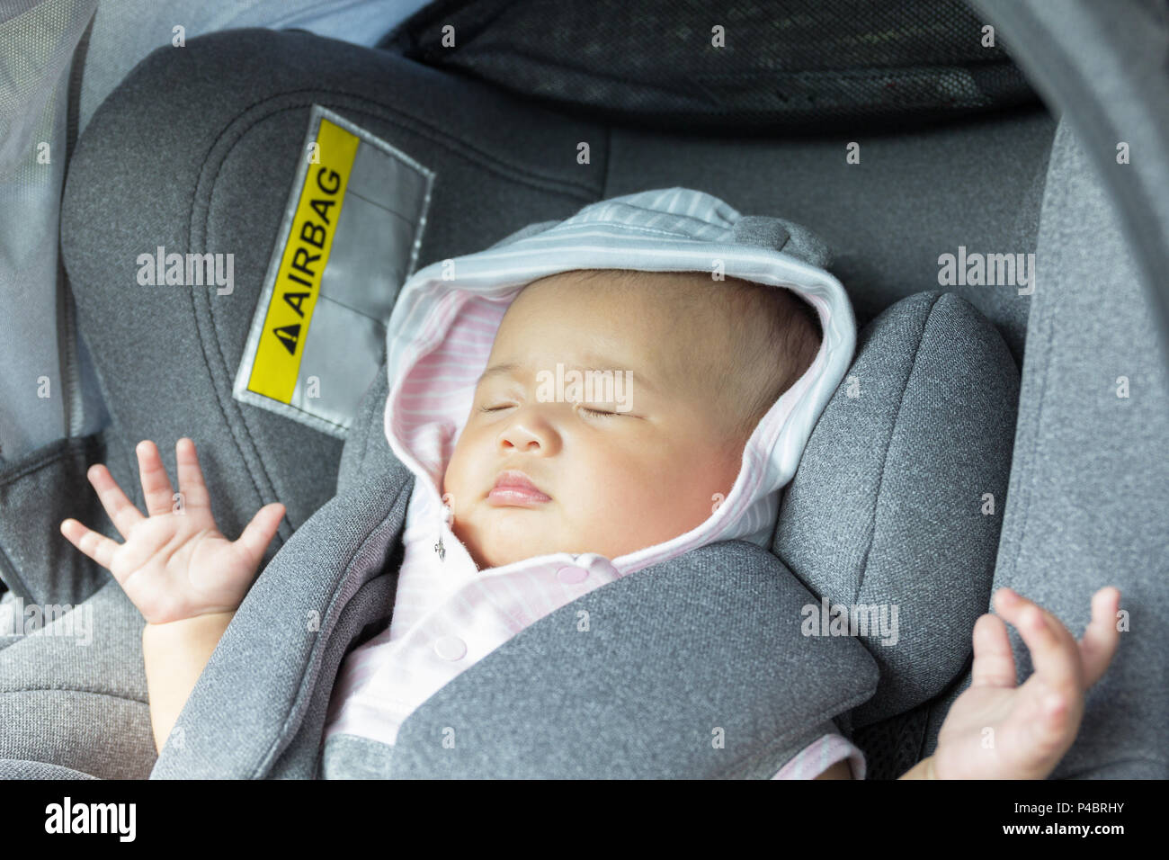 Asian cute newborn baby sleeping in modern car seat. Child new born