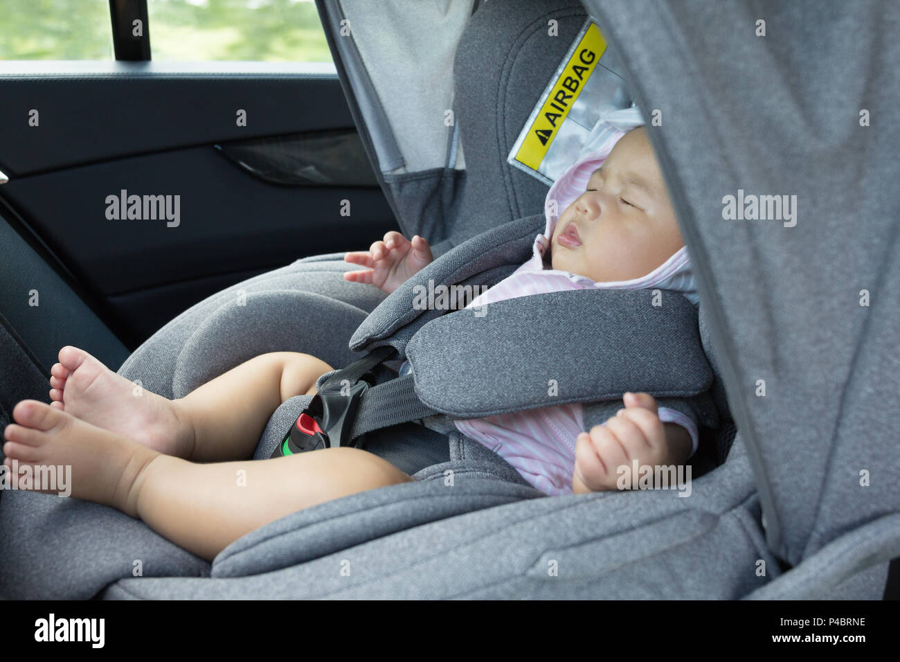 Close Up Asian cute newborn baby sleeping in modern car seat. Child new born traveling safety on