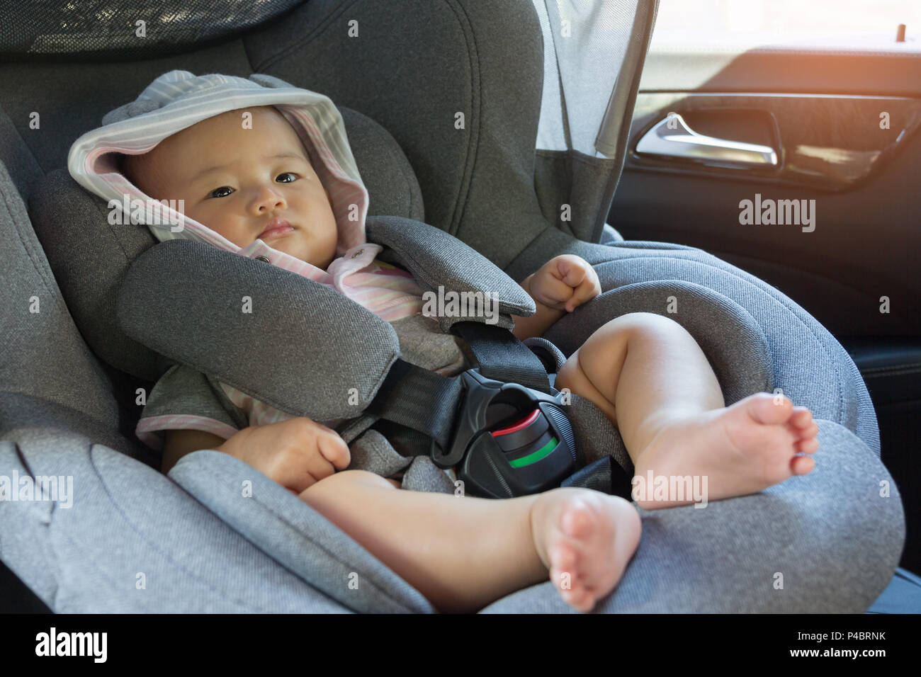 Close Up Asian cute newborn baby sitting in modern car seat. Child new
