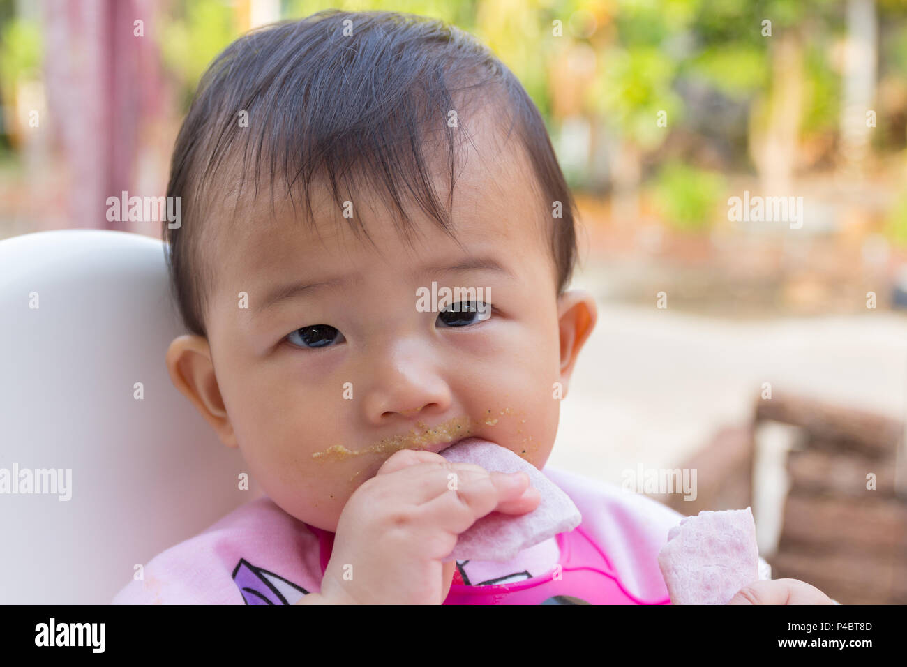 Asian cute baby eating food, snack for young kid seven month at the