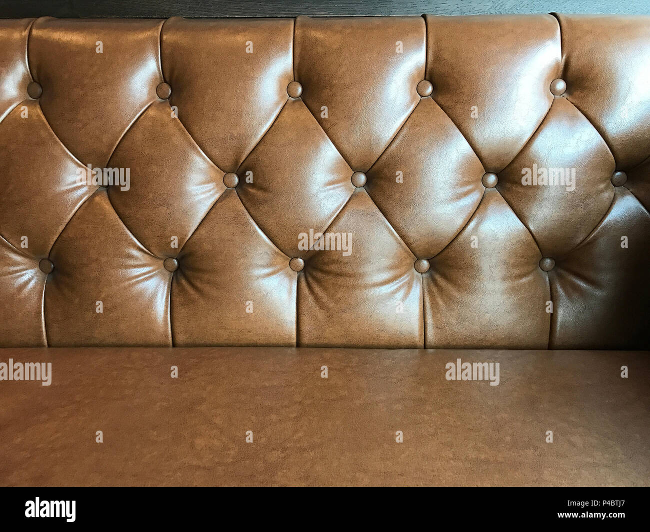 Vintage brown leather texture sofa background, in the cafe. Stock Photo