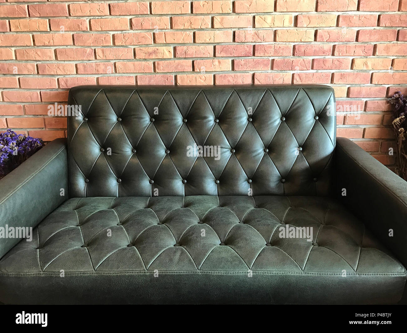 Vintage black leather texture sofa background, in the cafe. Stock Photo