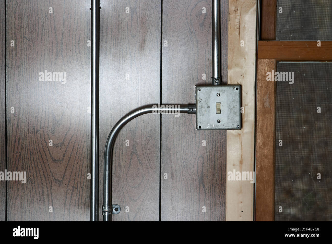 Old vintage metal electricity switch and junction box with exposed conduit  pipes on the surface mounted on a wooden wall alongside a door Stock Photo  - Alamy