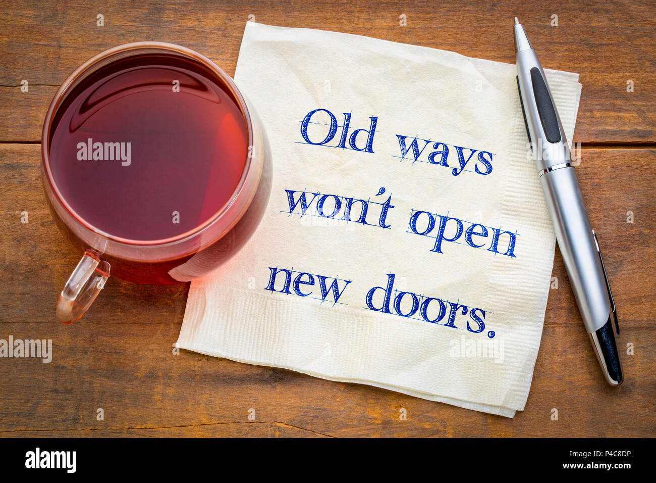 Old ways will not open new doors - handwriting on a napkin with a cup of tea. Stock Photo
