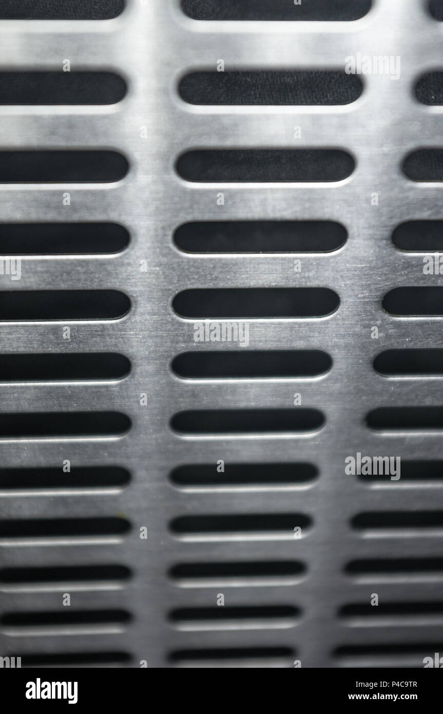 stainless steel grating with oblong holes on black background, close-up Stock Photo