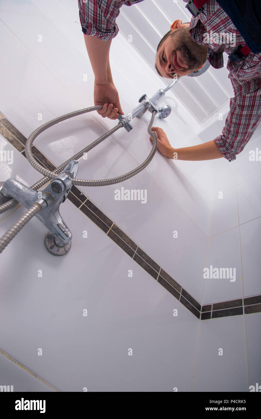 Handyman fixing the shower the bathroom Stock Photo Alamy