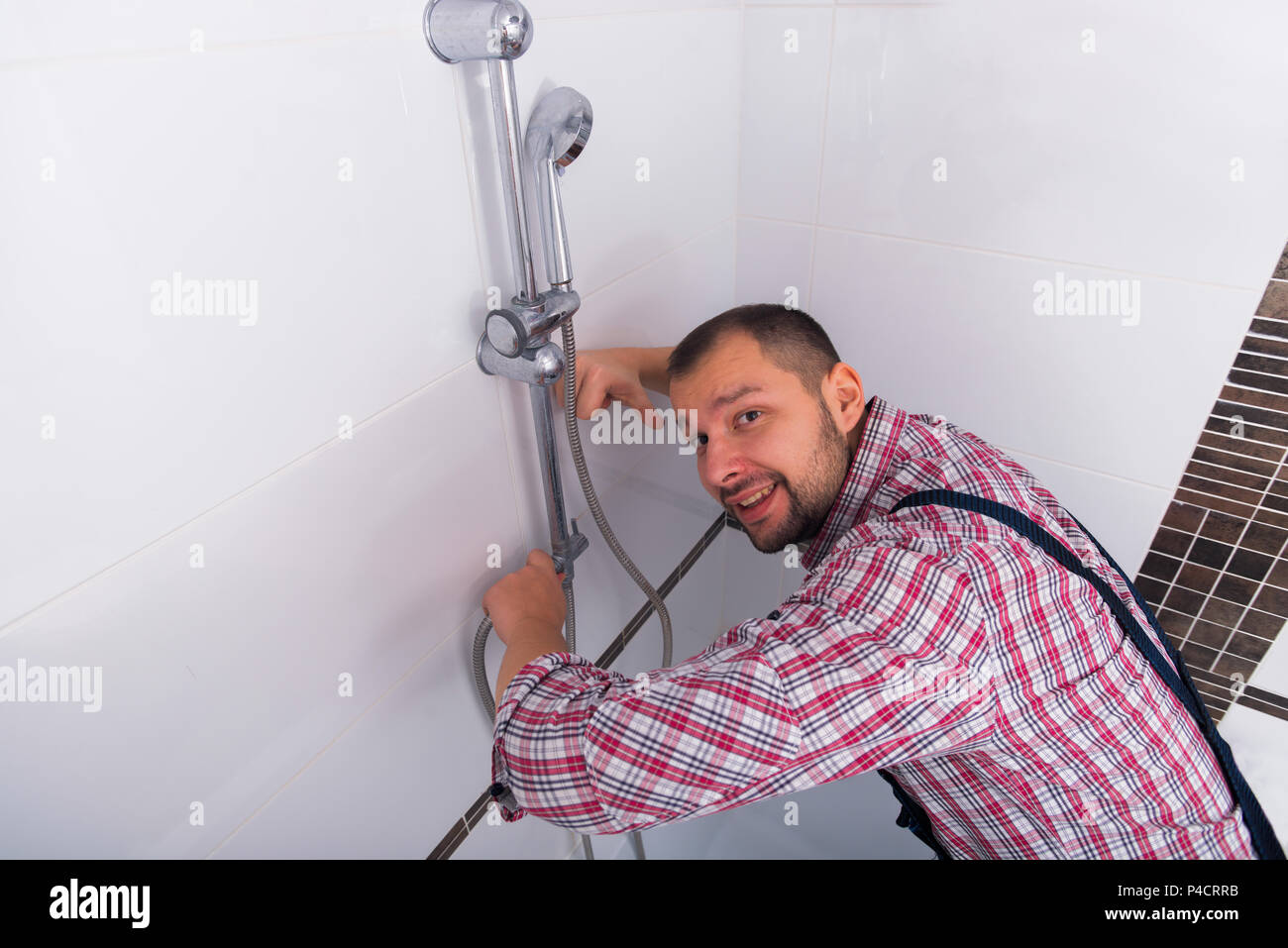 Handyman fixing the shower the bathroom Stock Photo Alamy