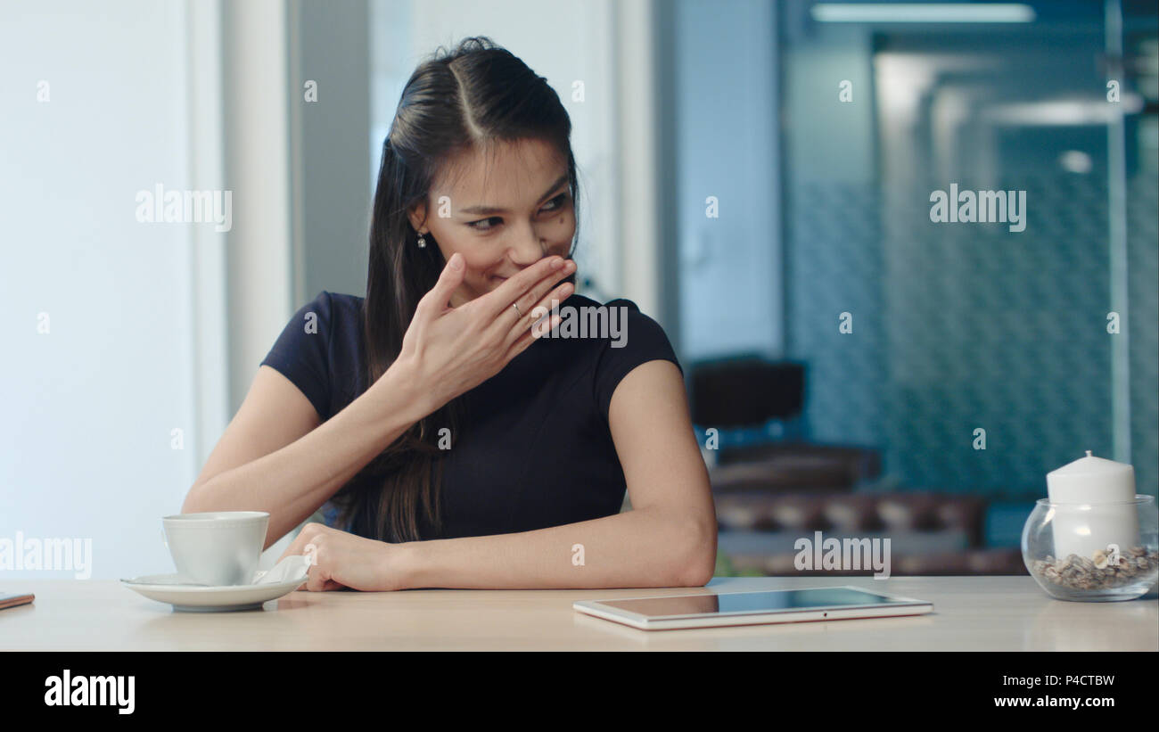 Pretty young woman drinking tea and flirting in a coffee house Stock Photo