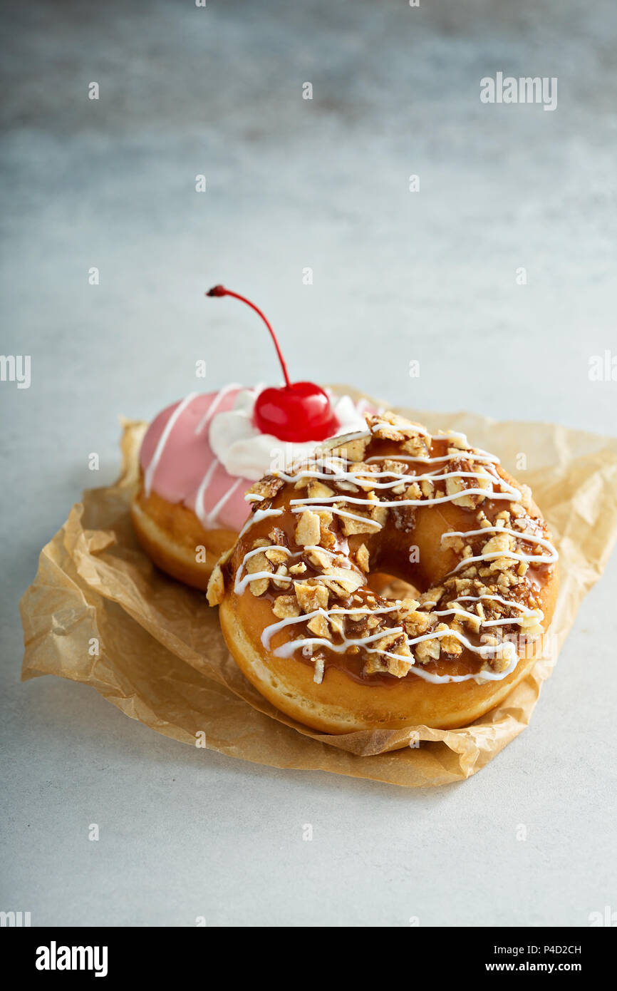 Assorted glazed fried donuts on parchment Stock Photo