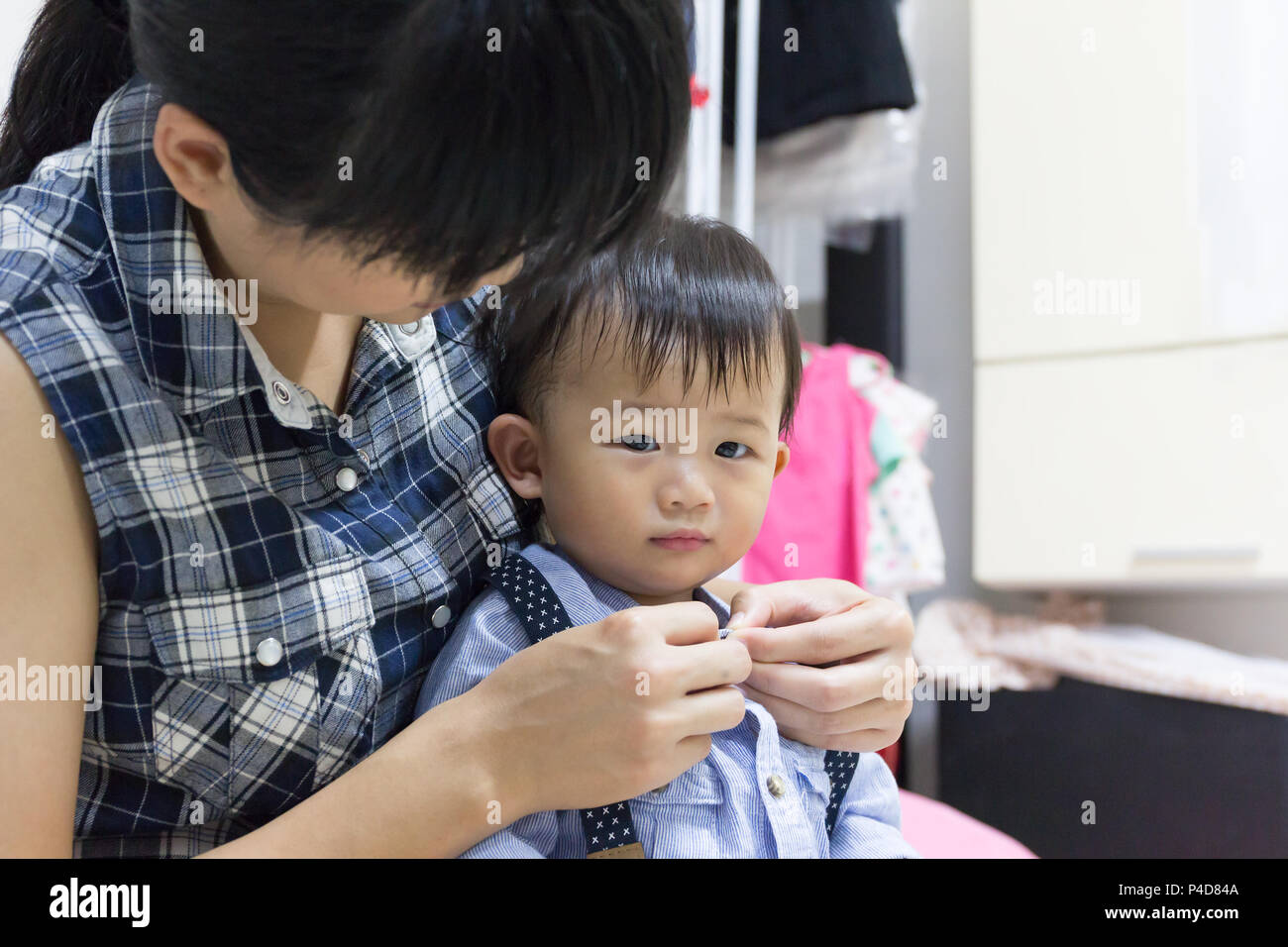 Asian cute baby is dressing up with support help by mother in room Stock  Photo - Alamy