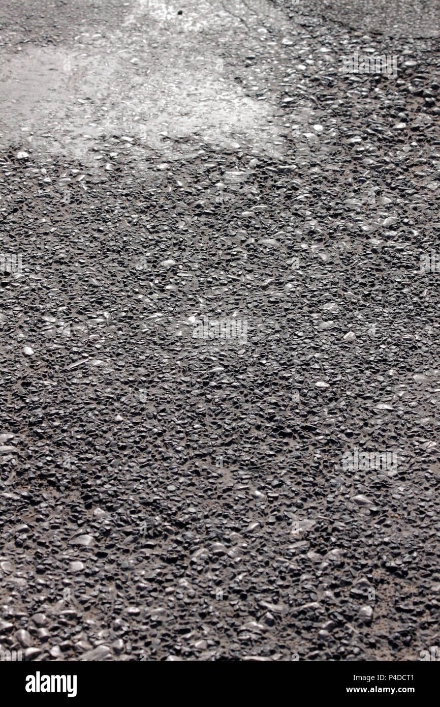 Aged coarse asphaltic road surface abstract texture close up Stock Photo