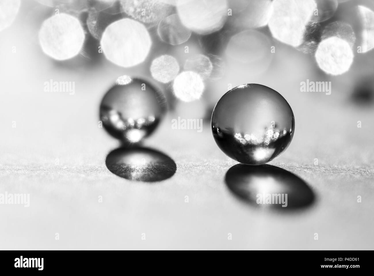 Little glass balls in direct sunlight, macro. Abstract background, black and white photo Stock Photo