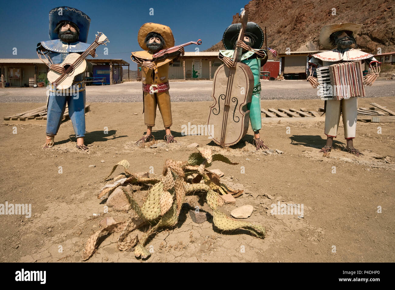 Metal figures of mariachi musicians serenading over dead cactus in Chihuahuan Desert at high noon, Study Butte near Big Bend National Park, Texas, USA Stock Photo