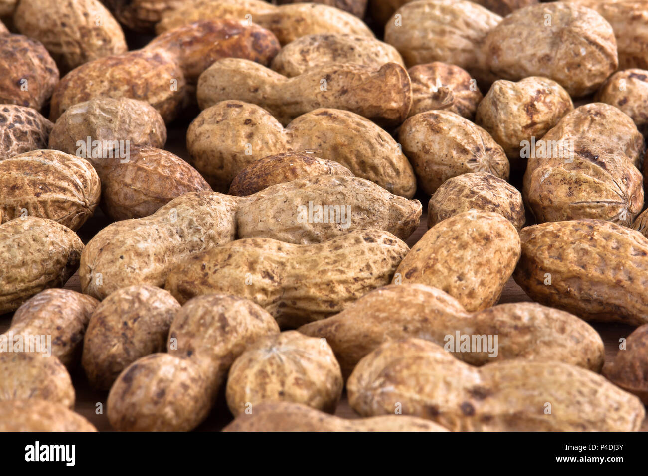 heap of unshelled peanuts as background, closeup Stock Photo