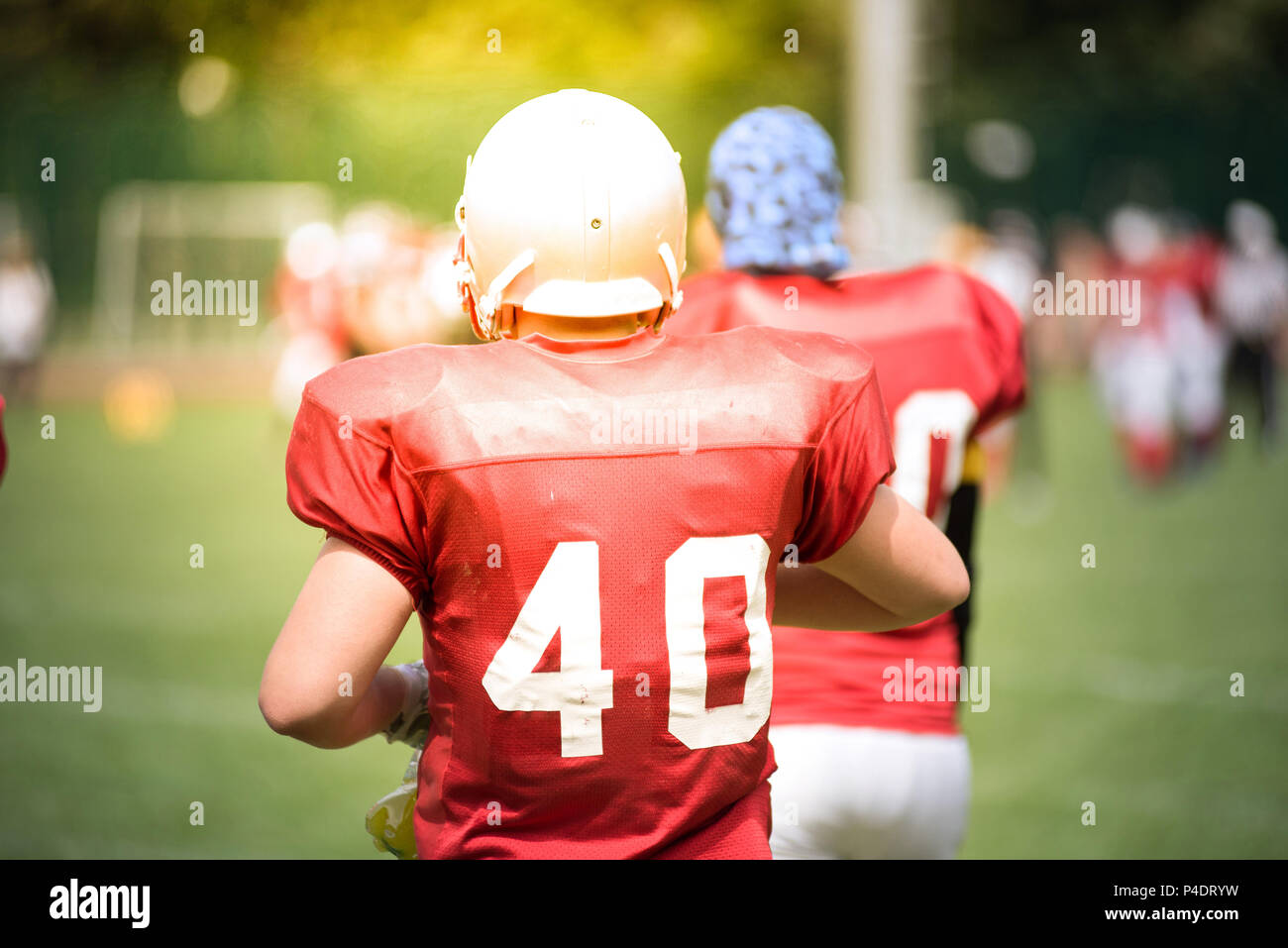 American Football players in action in the field. Sun flare effect Stock Photo