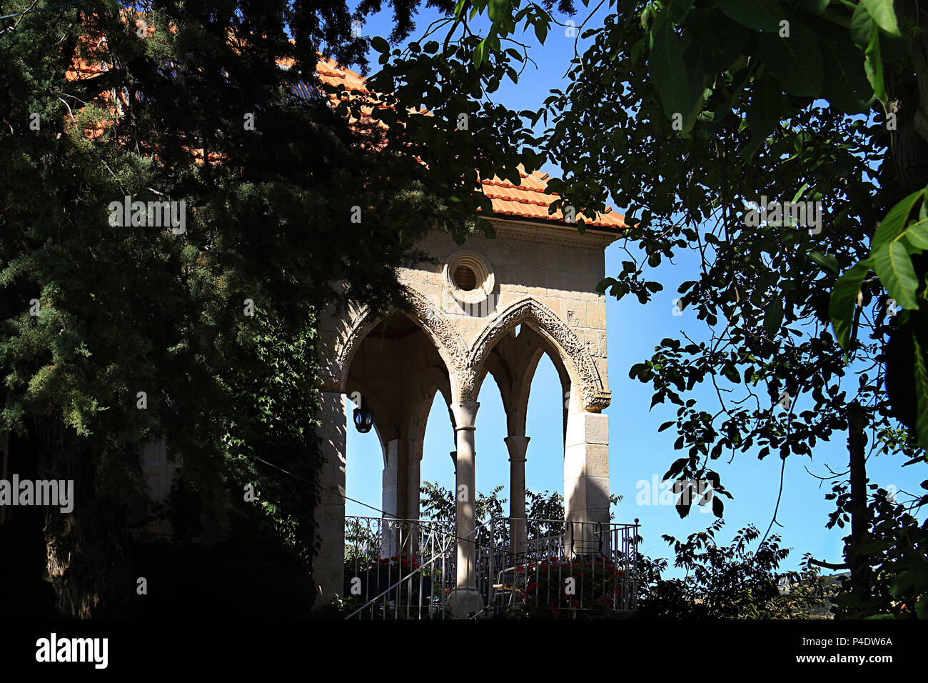 A traditional Lebanese house with arches from behind trees Stock Photo