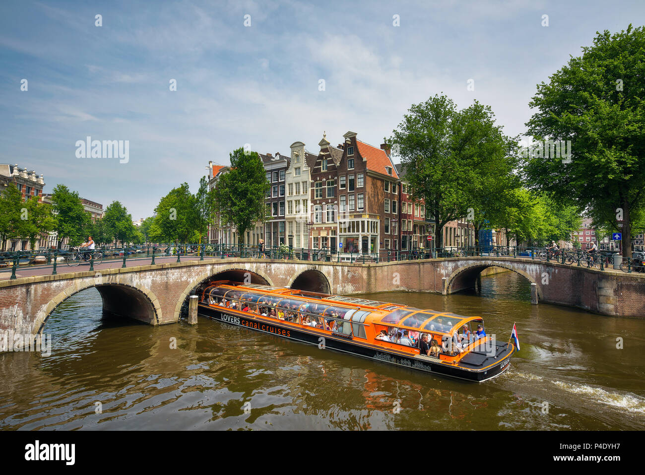 Boat with tourists boating through the Keizersgracht canal in Amsterdam Stock Photo