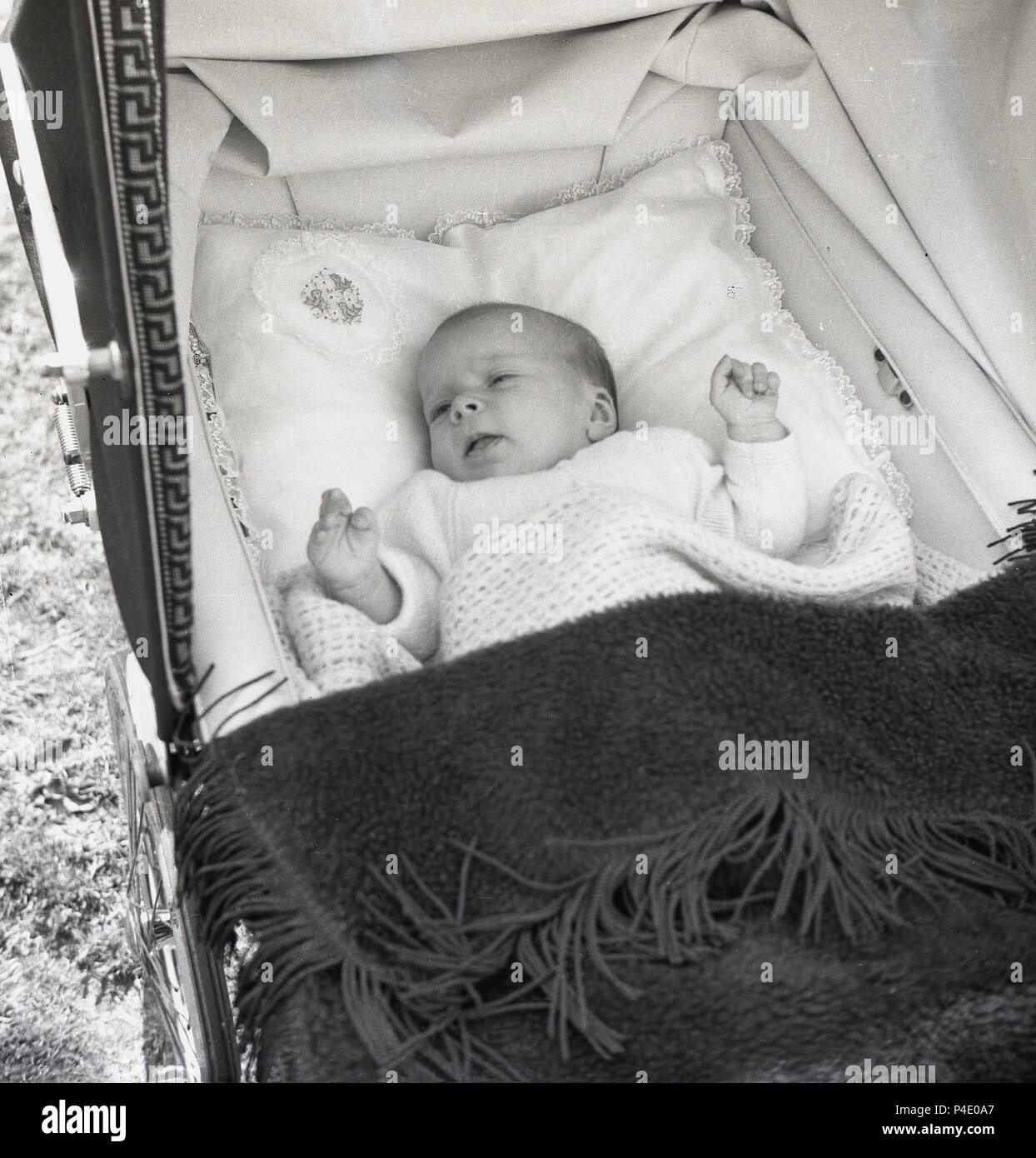 1950s, a baby lying comfortably in a Royale Baby Carriage or pram, England, UK. Founded in 1930 in London, by the Saward brothers, the company claimed to make 'the world's most beautiful prams'. Stock Photo