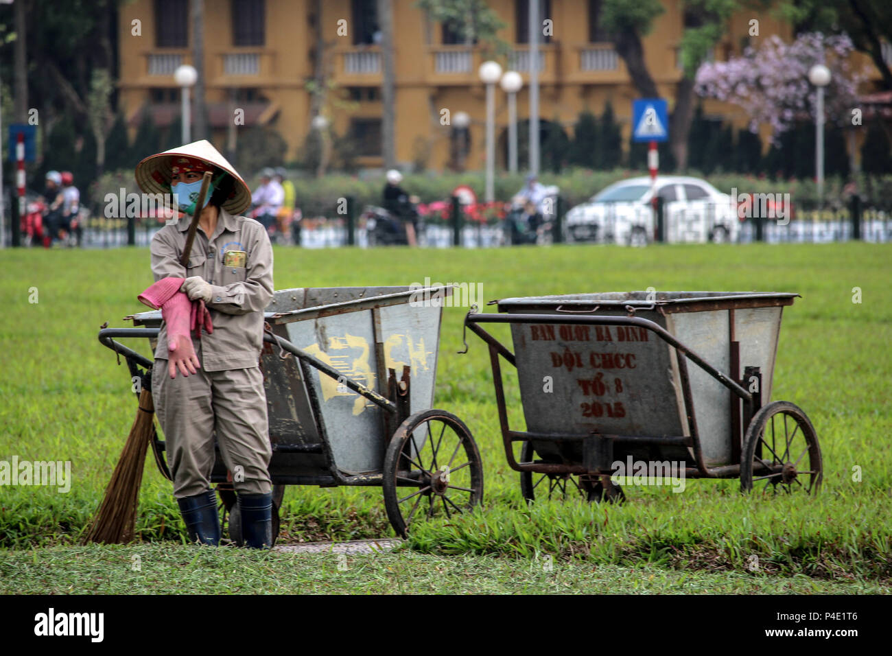 Hanoi, Vietnam - March 15, 2018: Gardener cleaning the grass between the Vietnamese government building and the Ho Chi Min mausoleum Stock Photo