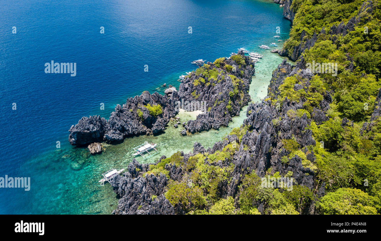 Aerial drone view of traditional banca boats next to a coral reef and beautiful, shallow tropical lagoon Stock Photo