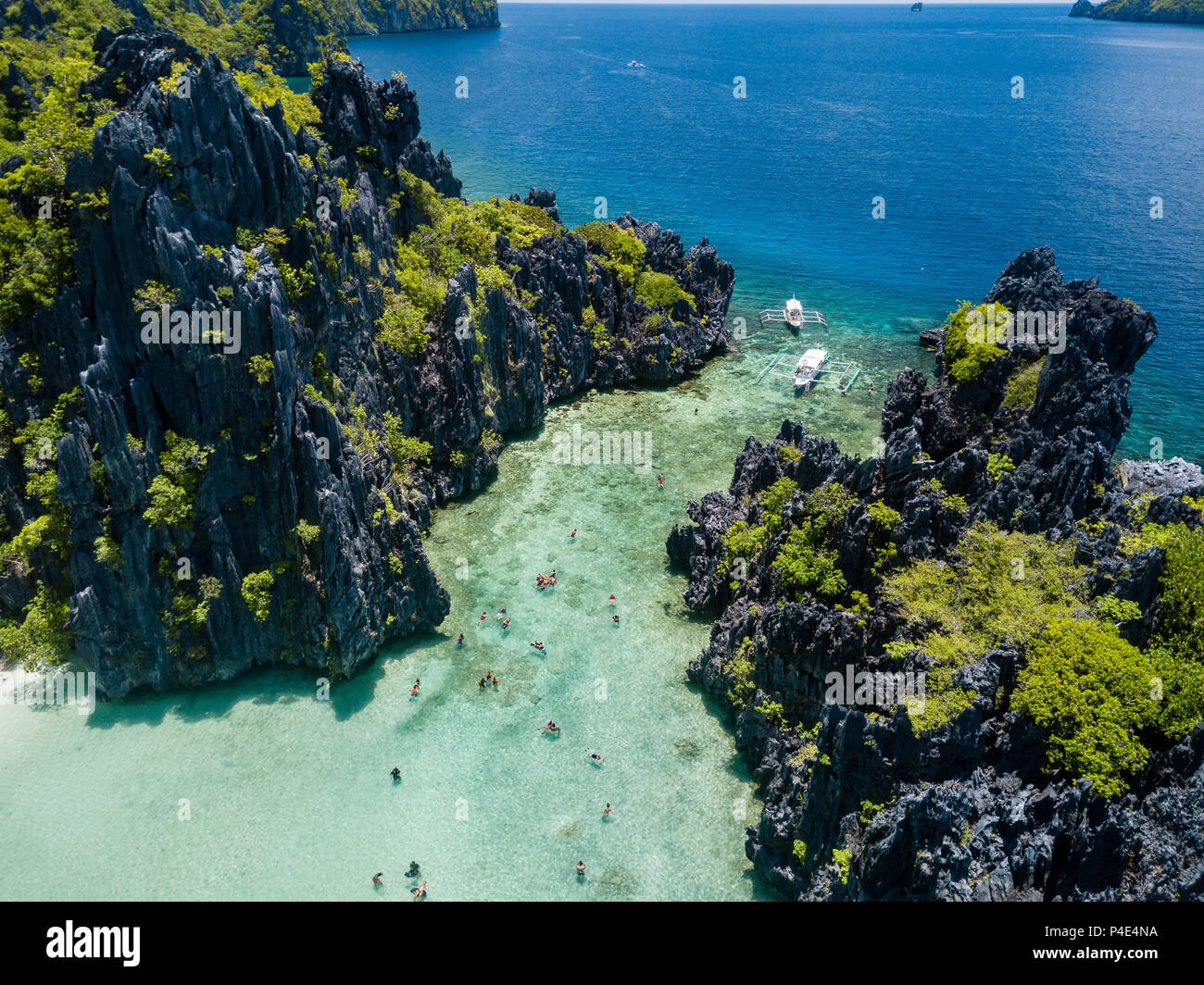 Aerial drone view of swimmers and snorkelers inside a beautiful shallow tropical lagoon Stock Photo