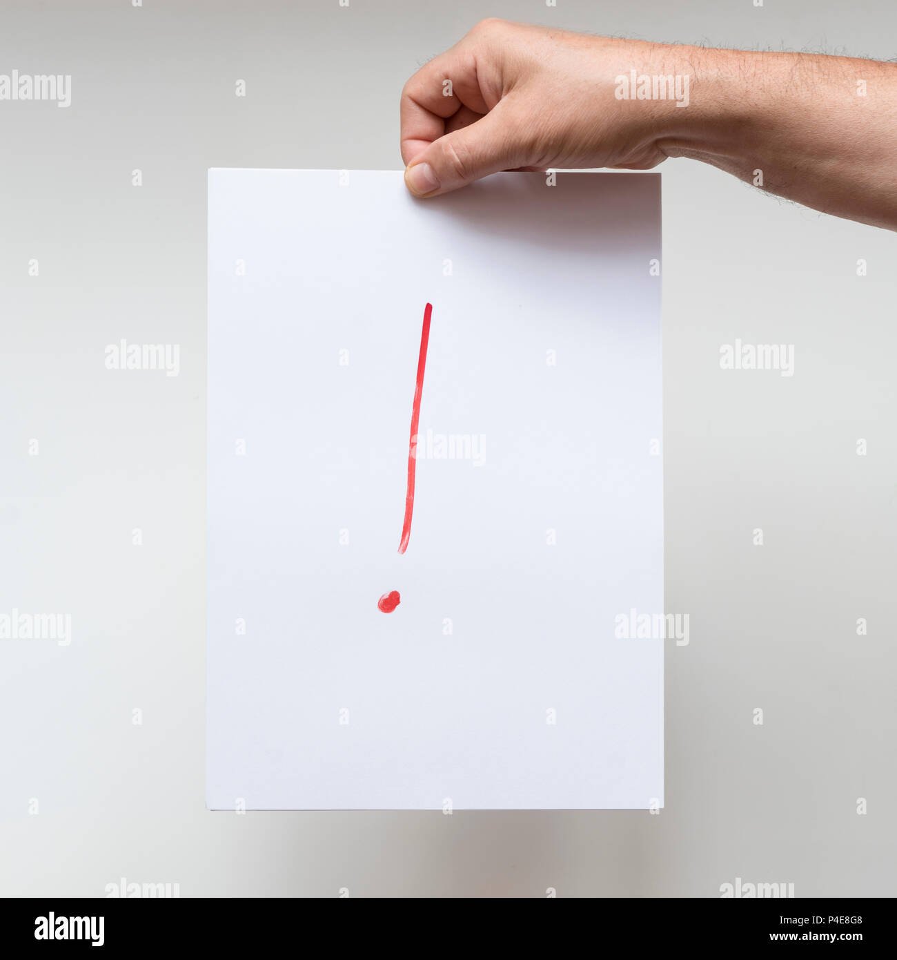an exclamation mark on a sheet of white paper Stock Photo