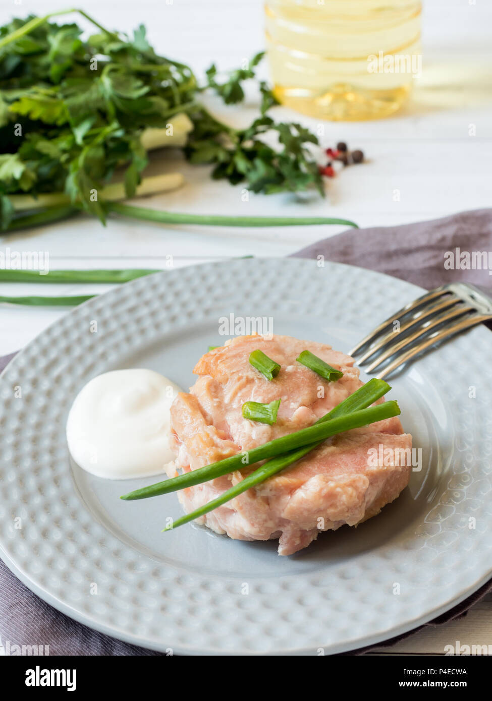Canned tuna in its own juice with green onions on a plate Stock Photo