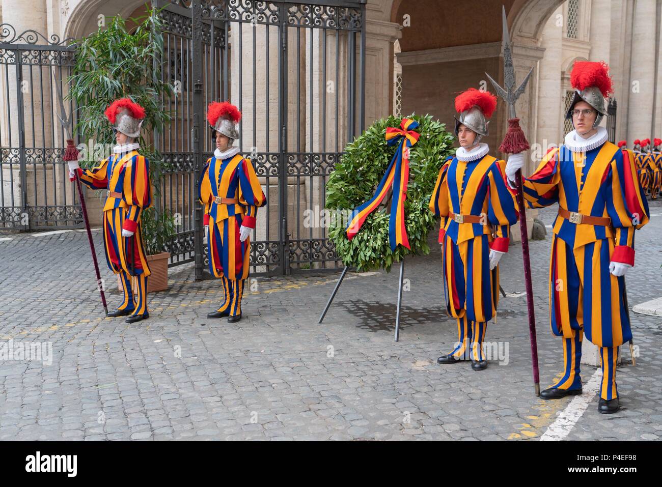 6 May 2018, Italia, Vatican: Guardsmen of the Pontifical Swiss Guard stand next to a wreath laid down every year at Campo Santo Teutonico in the Vatican in honor of the comrades who fell at the 'Sacco di Romai' in 1527. | usage worldwide Stock Photo