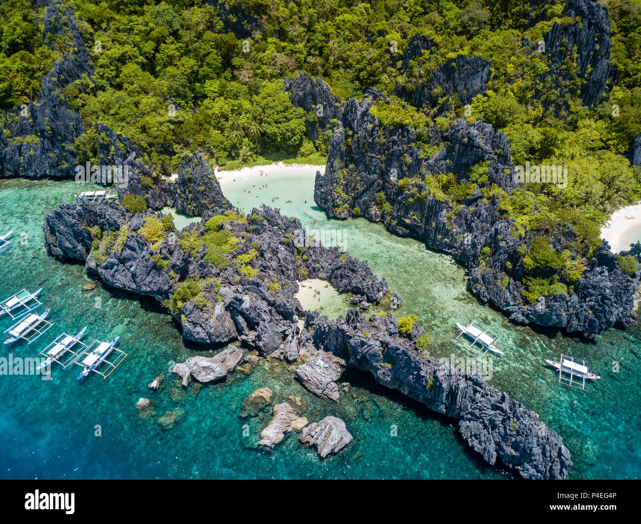Aerial drone view of boats, a shallow lagoon and beautiful hidden sandy beach Stock Photo