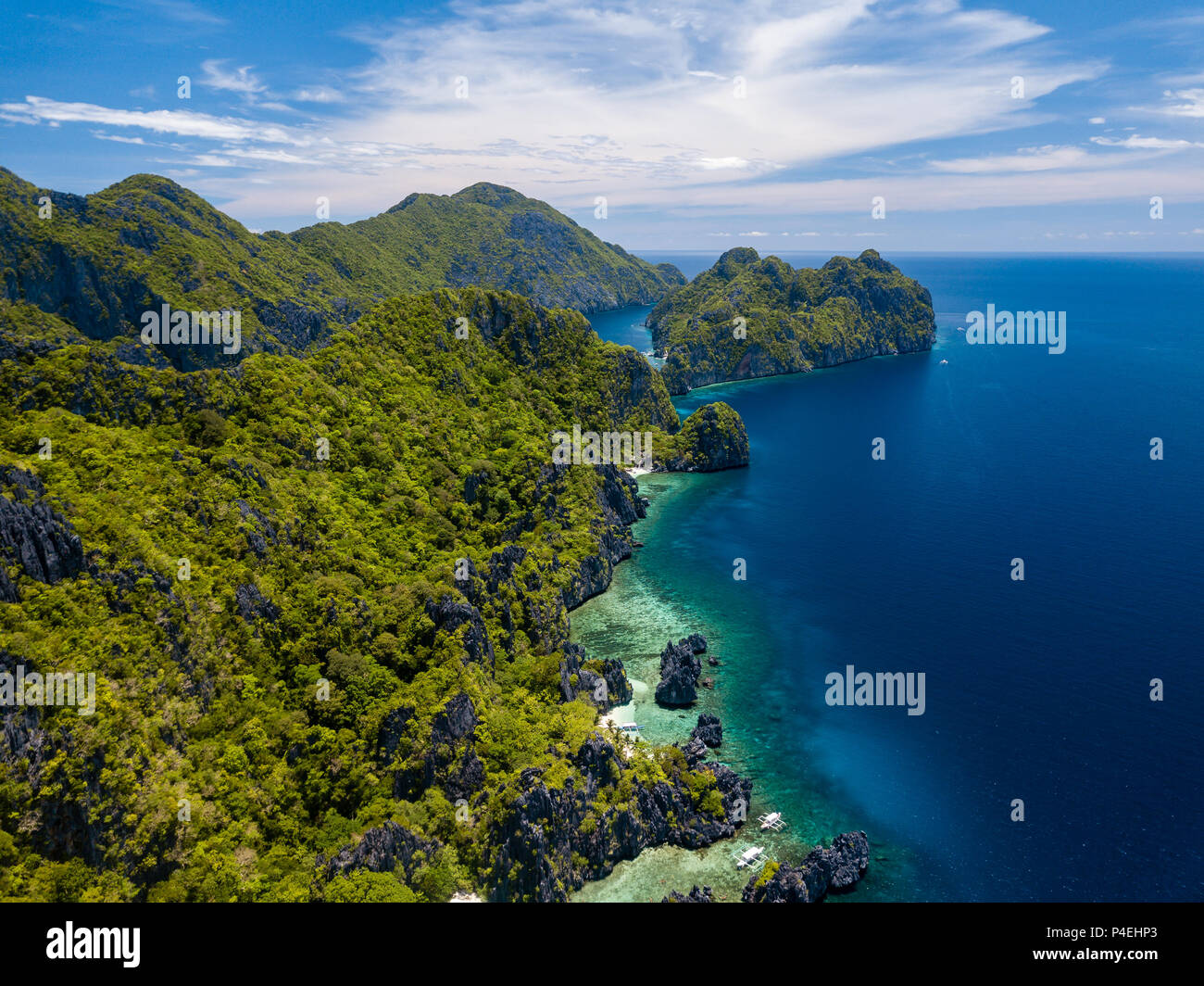 Aerial drone view of spectacular tropical scenery with towering cliffs, jungle and pristine sandy beaches Stock Photo