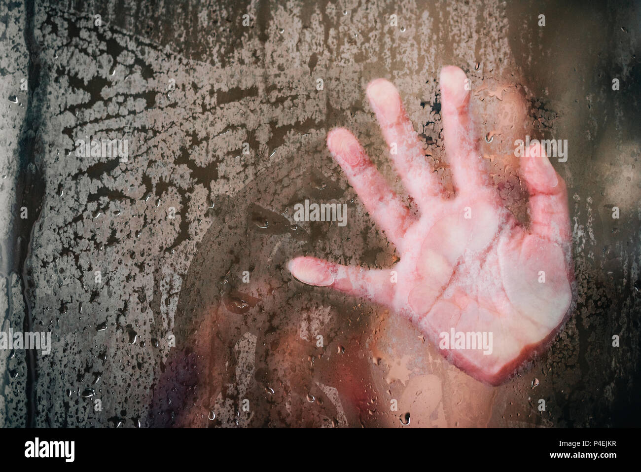 Girls hand wiping steam from the shower glass Stock Photo