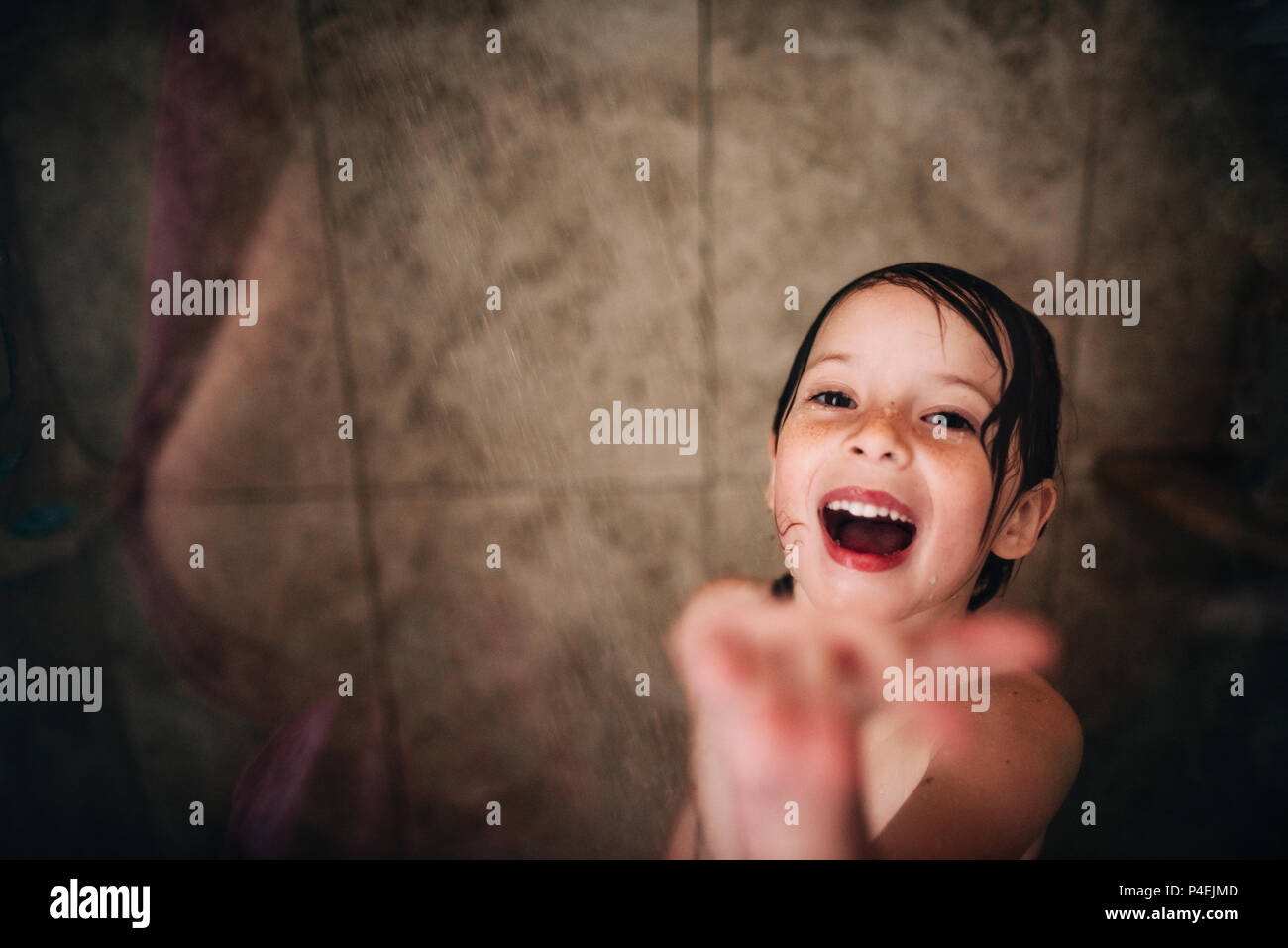 Girl standing in the shower laughing Stock Photo