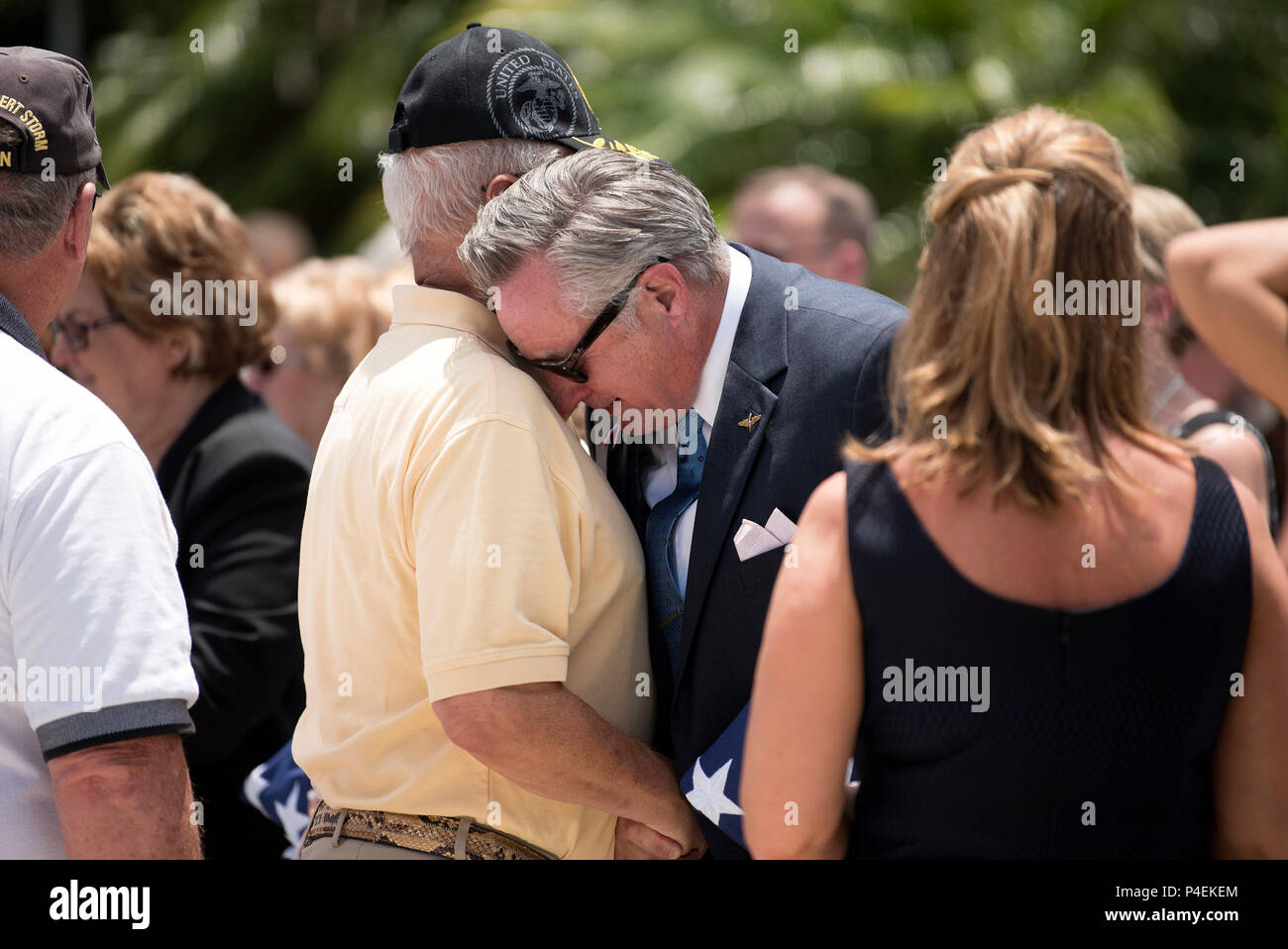 Bill Stewart, youngest son of U.S. Air Force Col. Peter Stewart, an F-4C  Phantom II aircraft pilot during the Vietnam War, hugs a Veteran during his  father's military honors service at St.