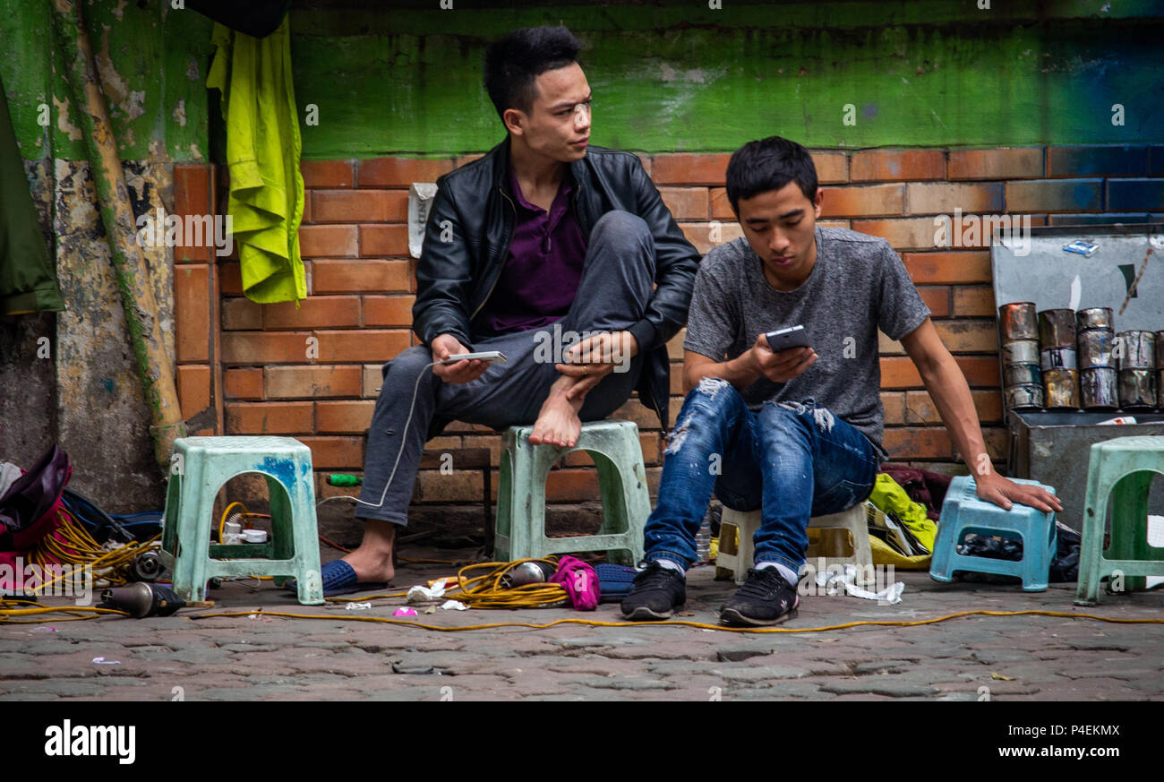 Hanoi, Vietnam March 15, 2018 Street workers sitting on plastic