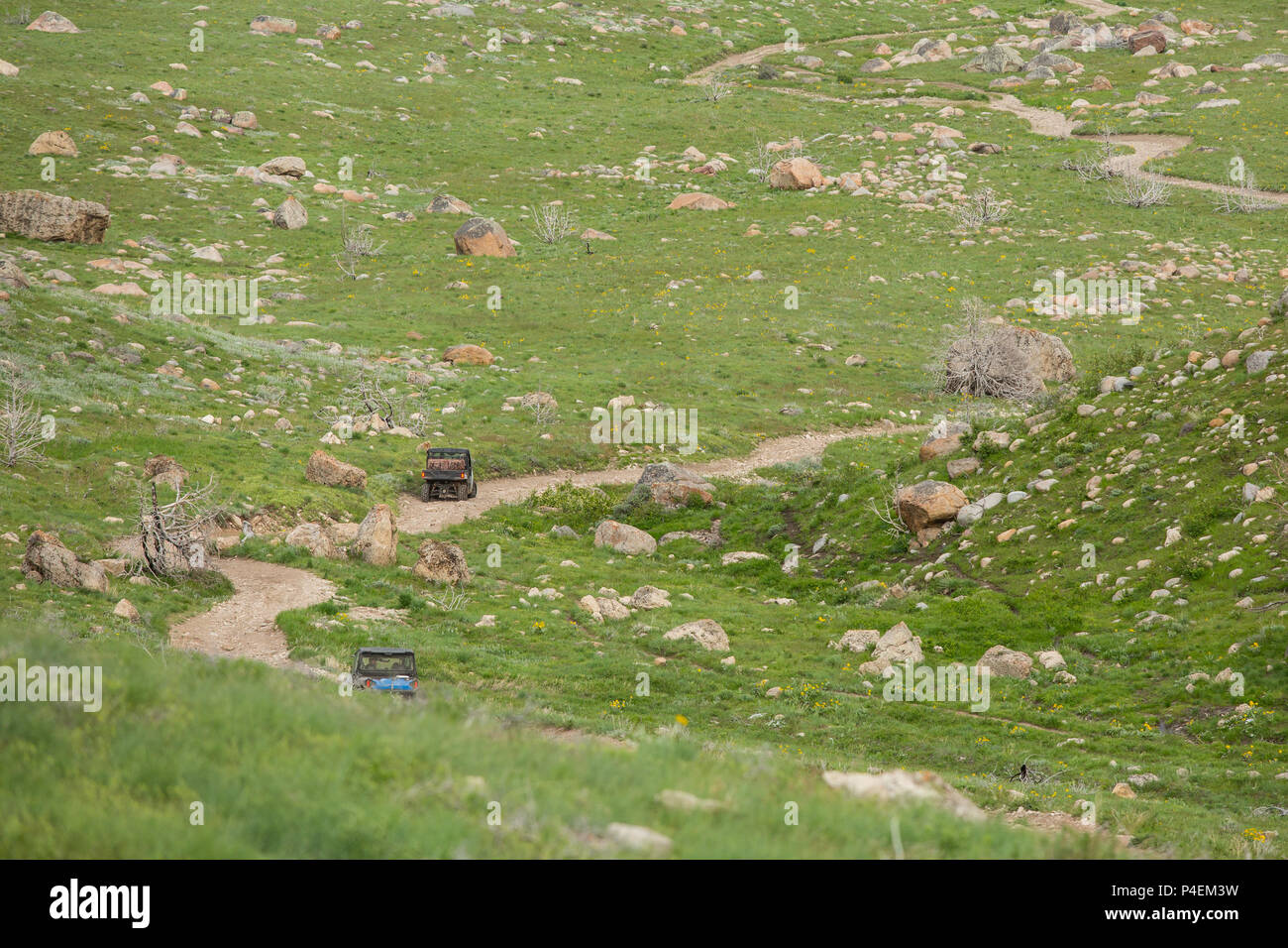 Two ATVs driving along a dirt road, Wyoming, United States Stock Photo