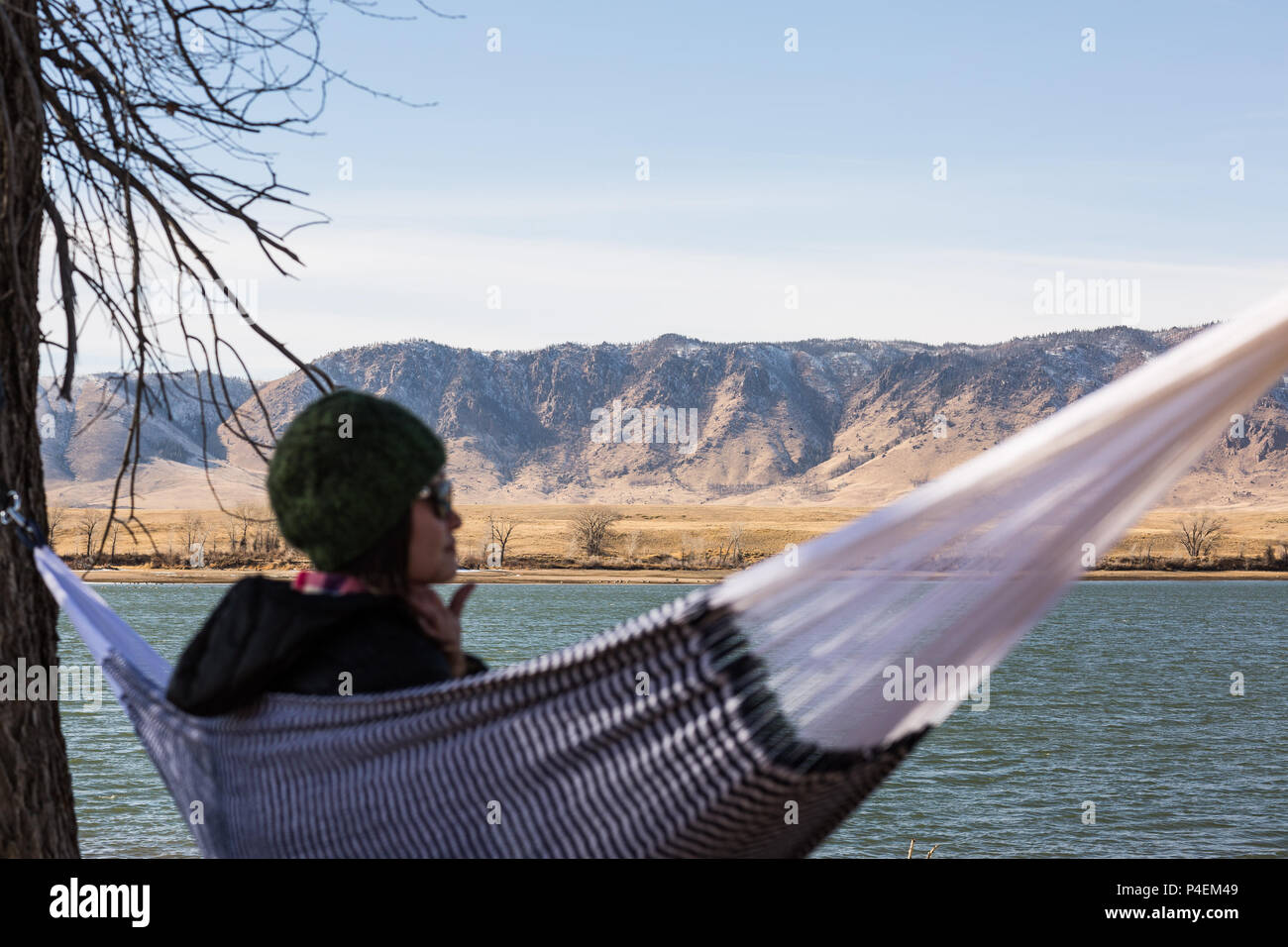 Woman sitting in a hammock by a lake, Wyoming, America, USA Stock Photo
