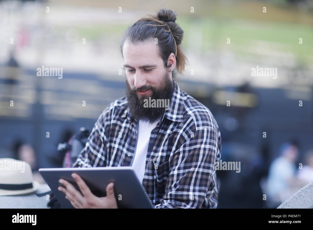 Man sitting outdoors using a digital tablet Stock Photo