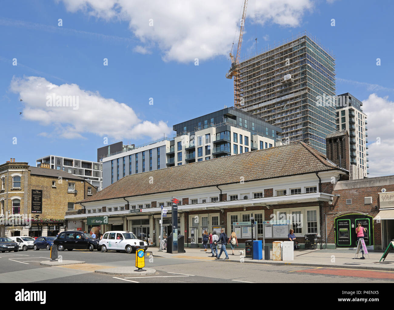 Exterior view of Sutton Station in South London, UK. Traditional Victorian station building spans the lines below. Shows main entrance and taxi rank. Stock Photo